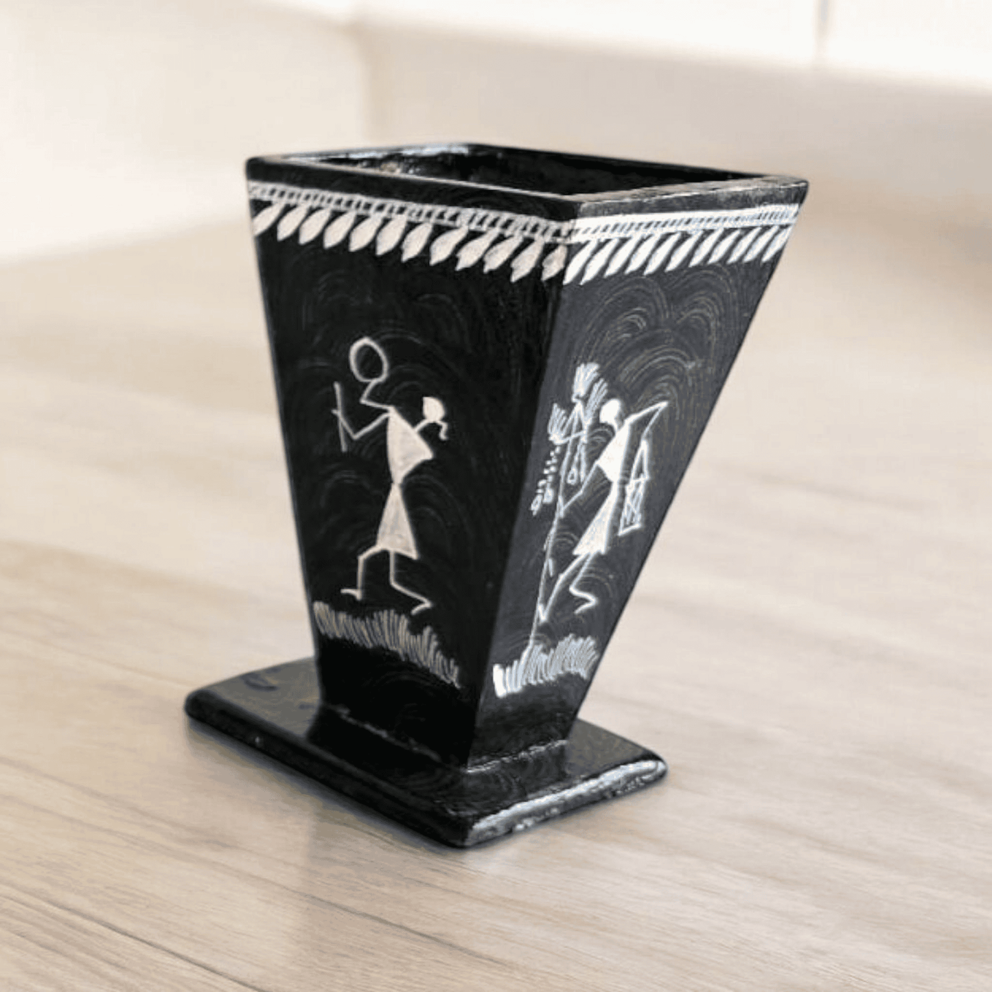 black Pen holder with white warli art on it