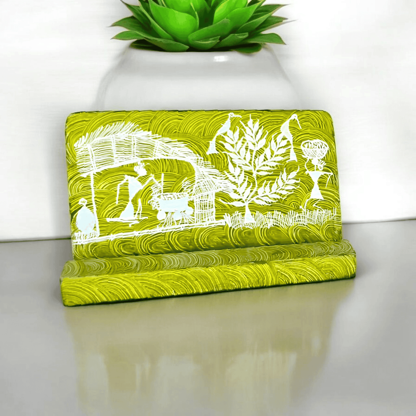 A green wooden mobile stand with hand-painted Warli tribal designs
