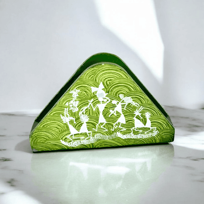 A triangular wooden napkin holder with Warli tribal artwork, predominantly green with white patterns