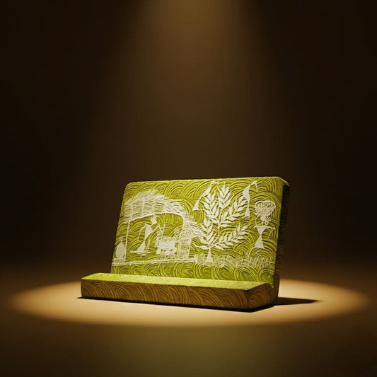 Green phone holder with white warli patterns on a dark background