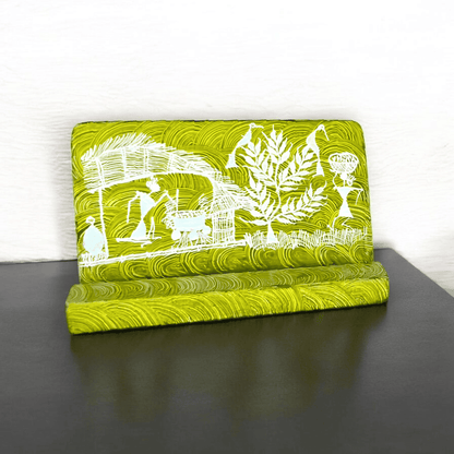 A green wooden mobile stand with hand-painted Warli tribal designs placed on a wooden surface.